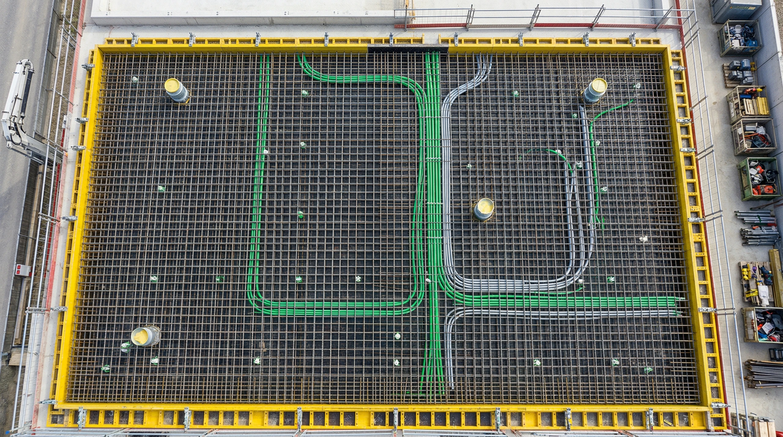 Draufsicht auf Armierungsmatten mit verlegten Leitungen auf der Bodenplatte