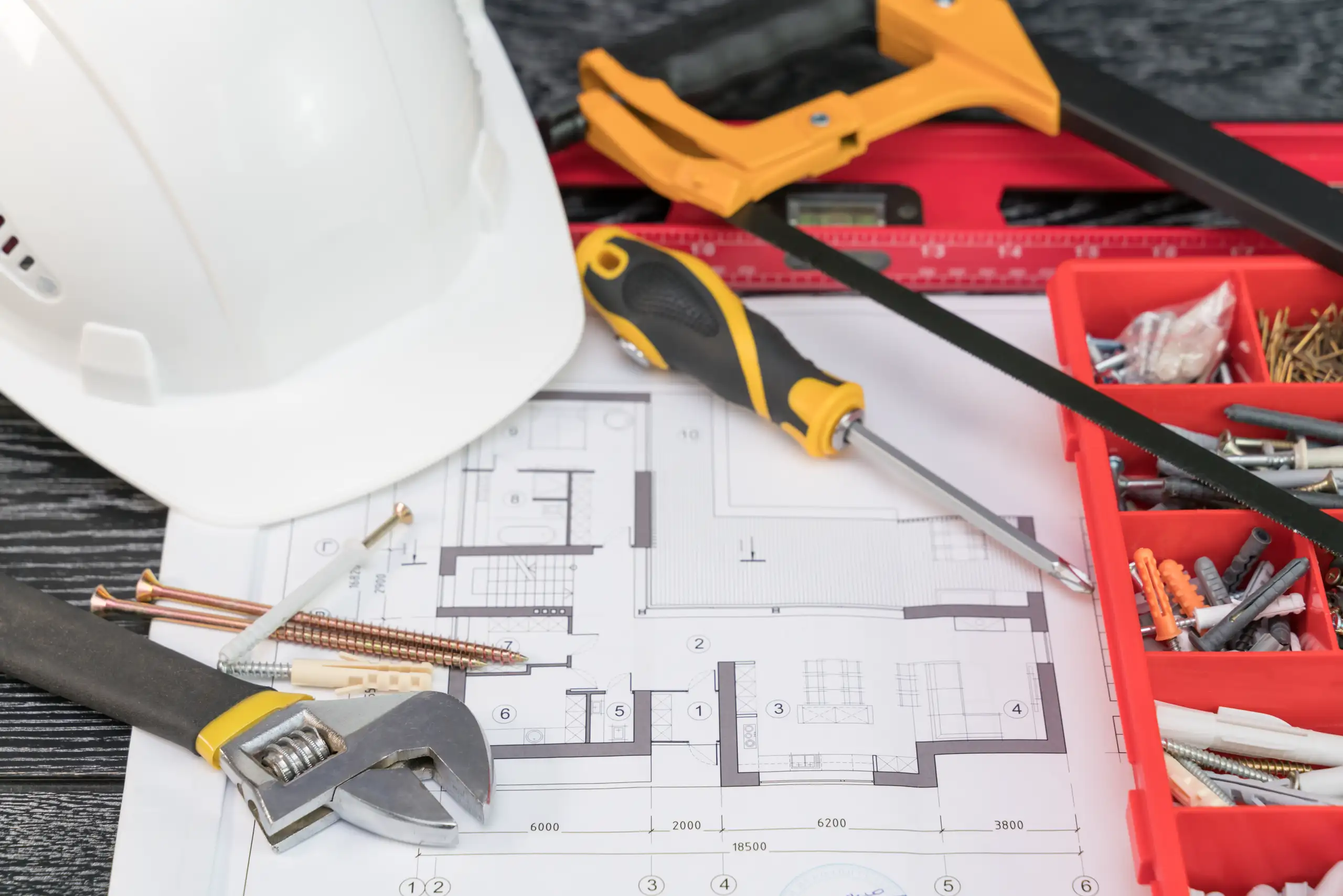 Bauleitung mit Bauplan, Schutzhelm und Montagewerkzeug