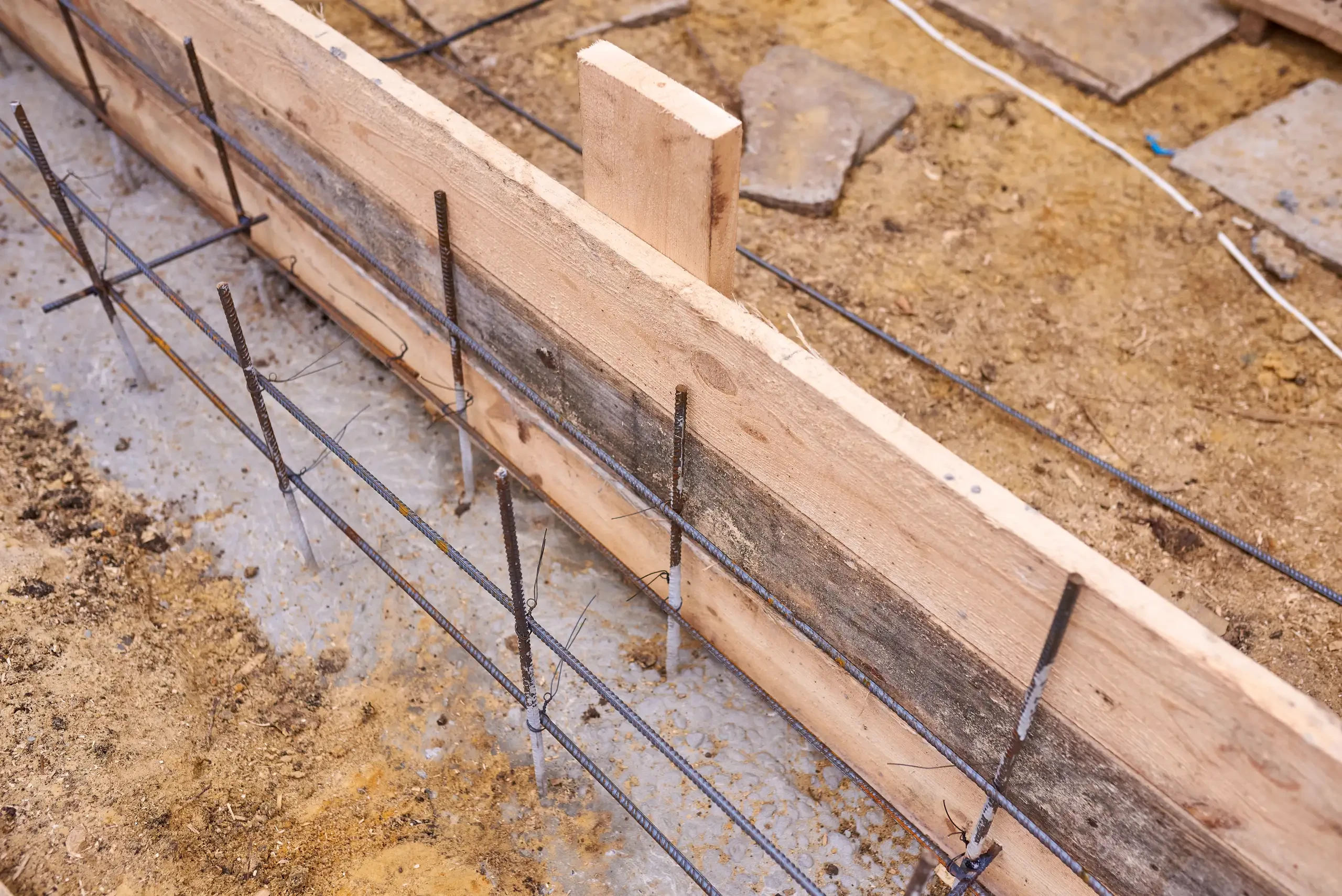 Holzschalung mit Bewehrungsstahl für Streifenfundamente auf Baustelle